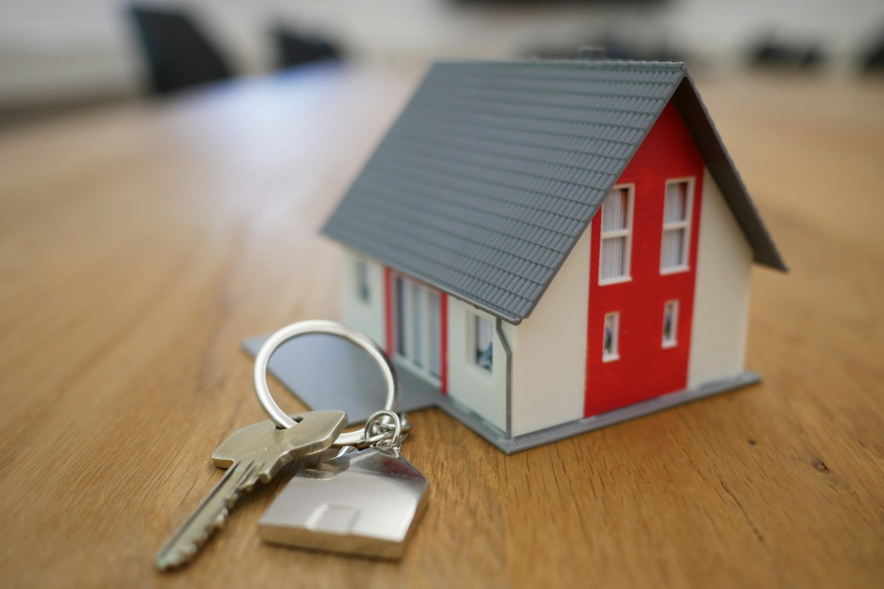 Maquette de maison et clés sur un bureau d'agence immobilière