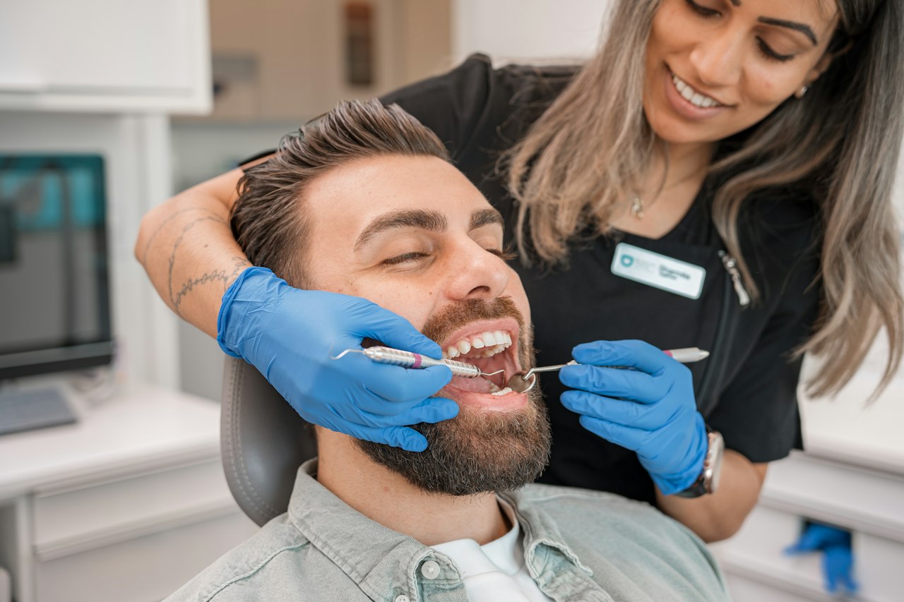 Chirurgien-dentiste souriant avec son patient au fauteuil