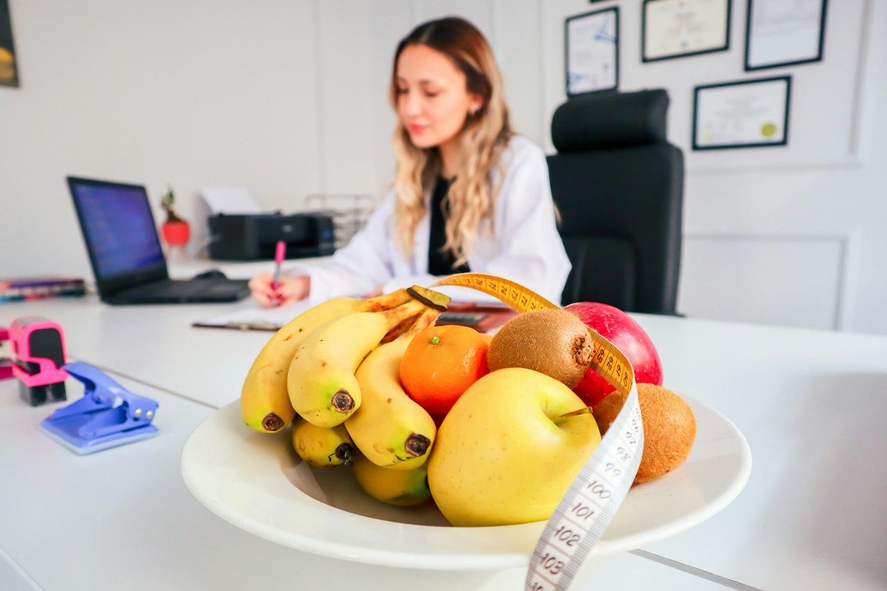 Diététicienne dans son cabinet avec une corbeille de fruits
