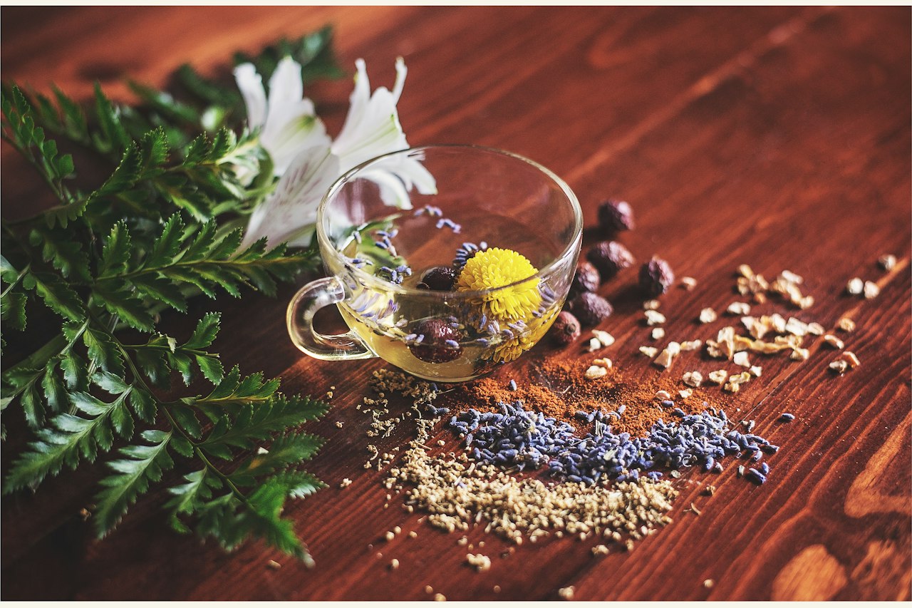 Plantes, graines et tisane sur une table en bois