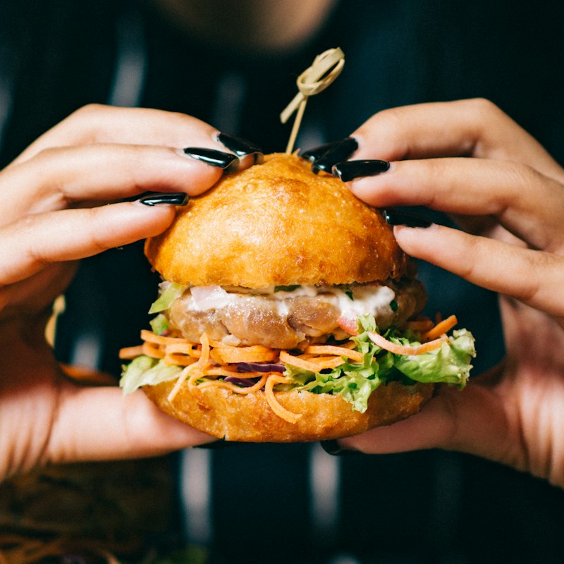 Burger de food truck tenu à deux mains