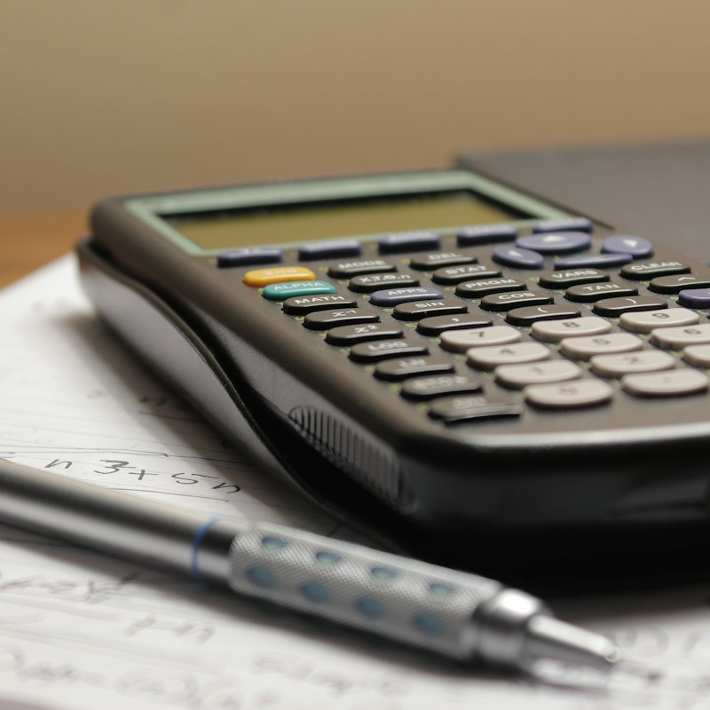 Calculatrice et stylo posés sur une facture