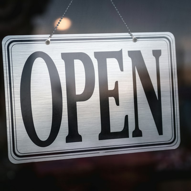 Panneau « Open » accroché à la porte d'une boutique
