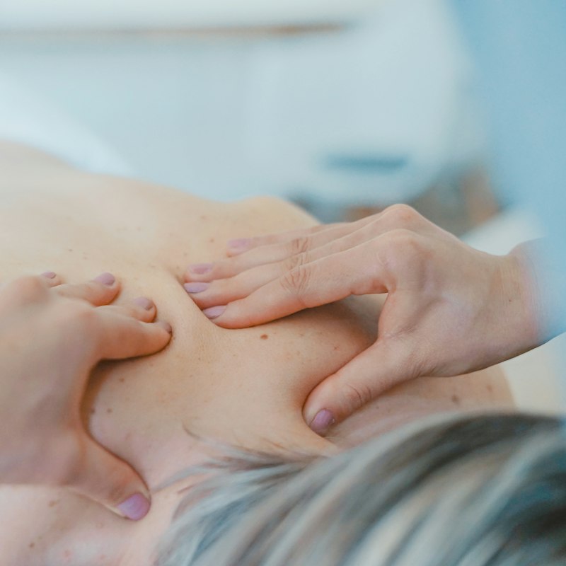 Mains d'une praticienne pendant un massage du dos