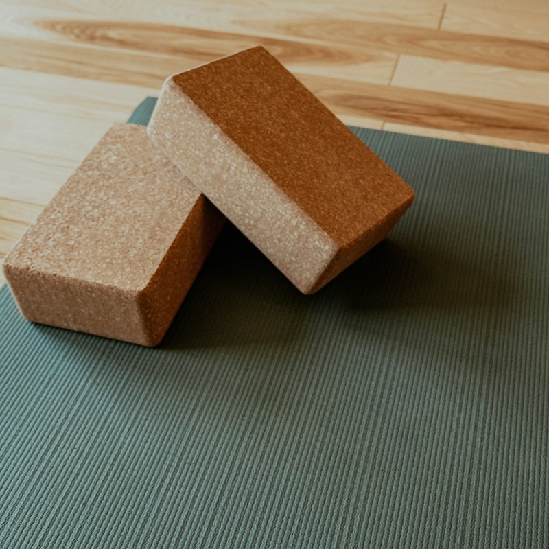 Tapis de yoga et briques en liège sur un parquet