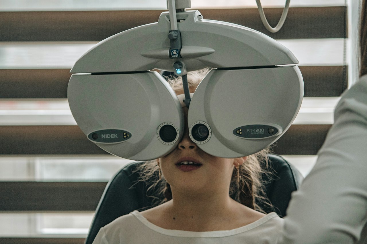 Enfant passant un examen de la vue avec un réfracteur