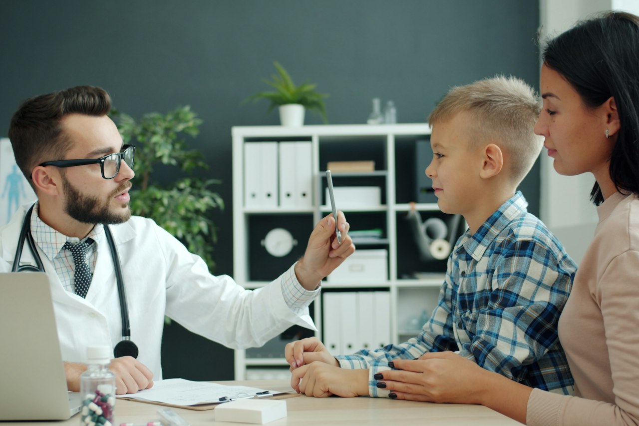 Médecin examinant un jeune garçon en présence de sa mère