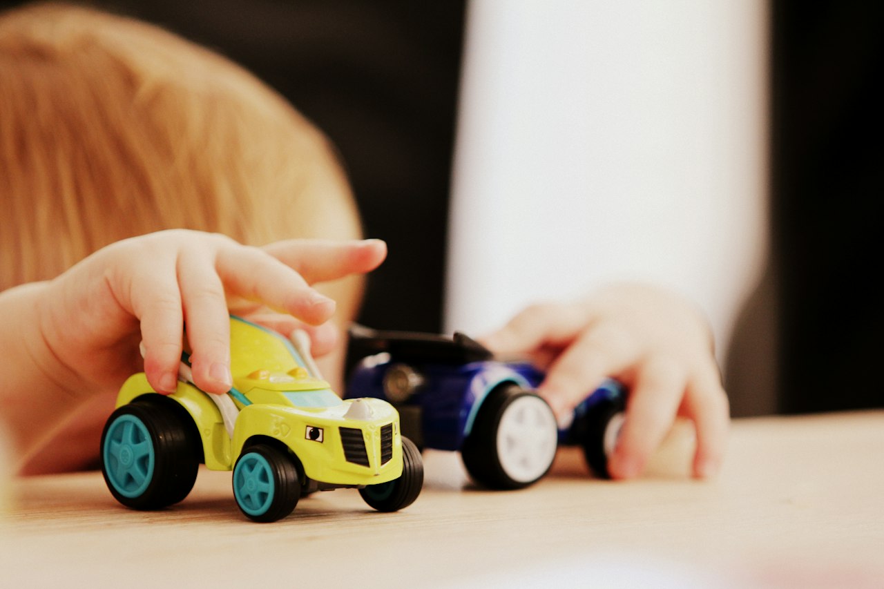 Enfant jouant avec des petites voitures sur une table