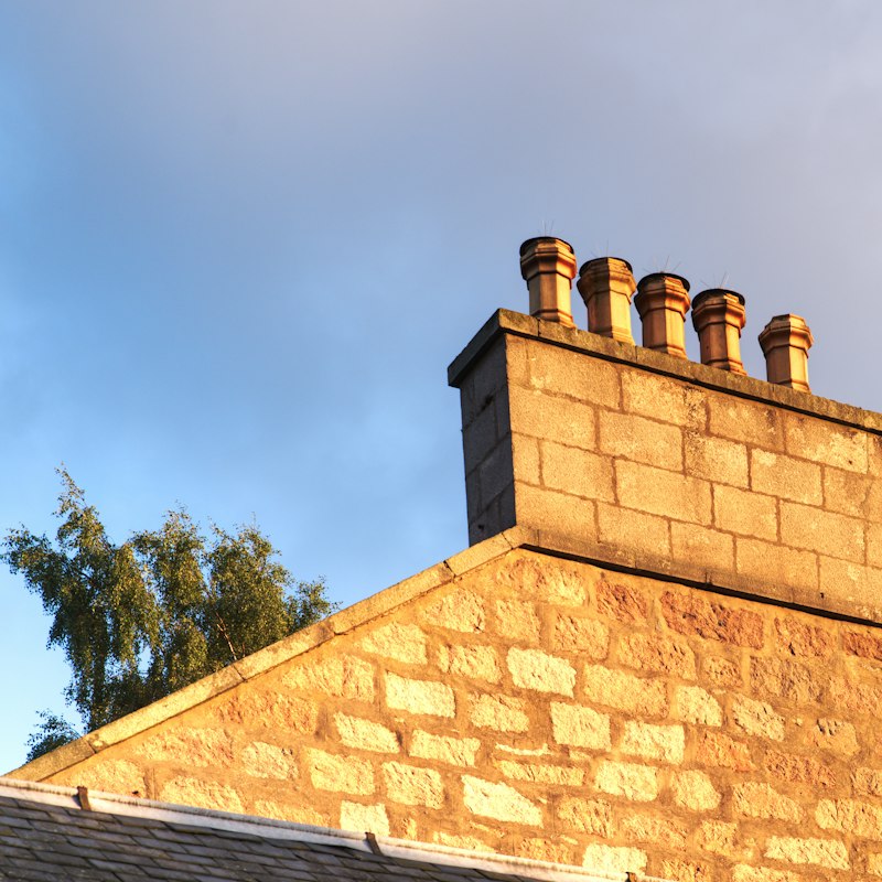 Cheminée en pierre sur un toit, ciel bleu
