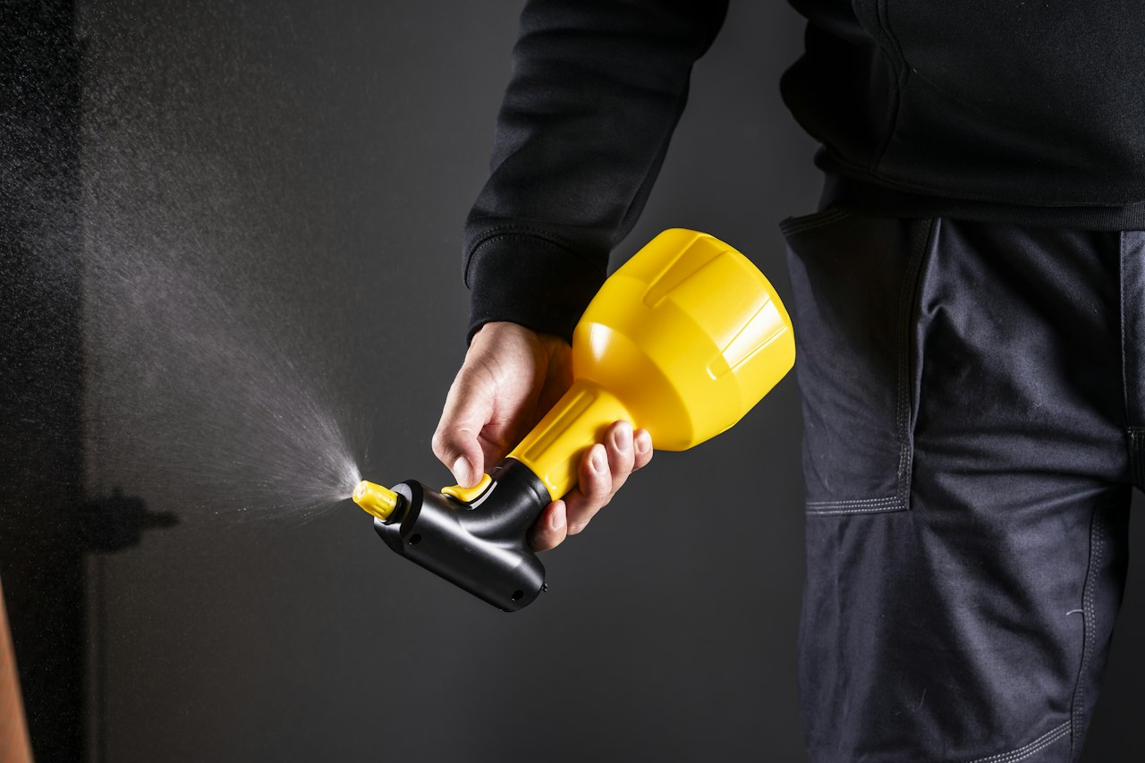 Technicien pulvérisant un traitement avec un pulvérisateur