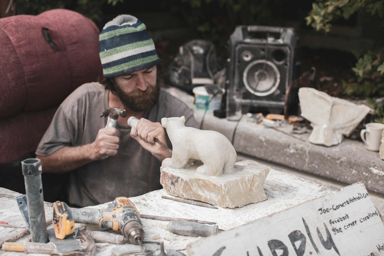 Tailleur de pierre sculptant un bloc dans son atelier