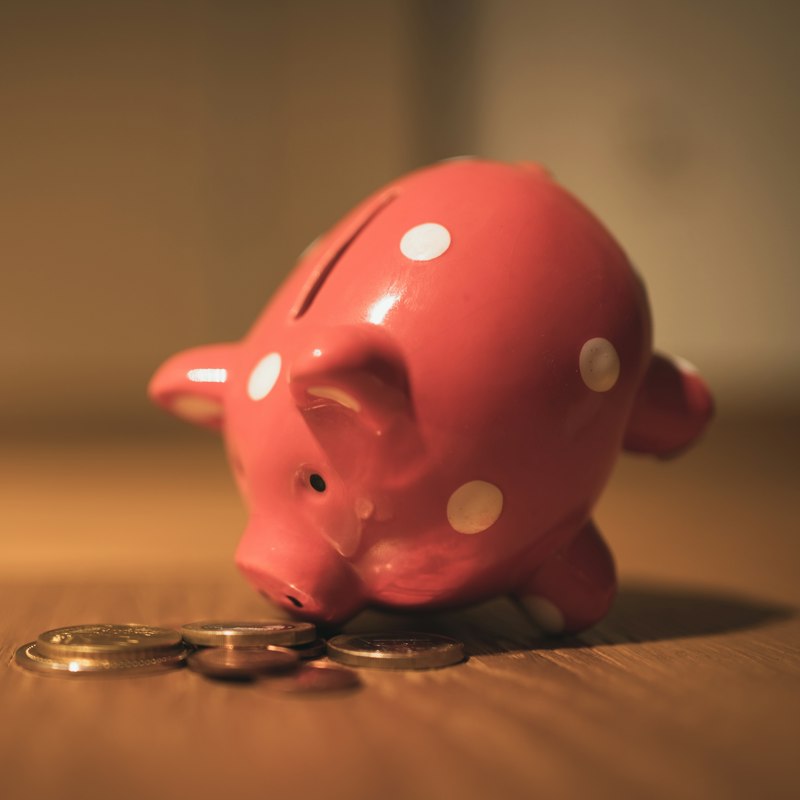 Tirelire rouge à pois et pièces de monnaie