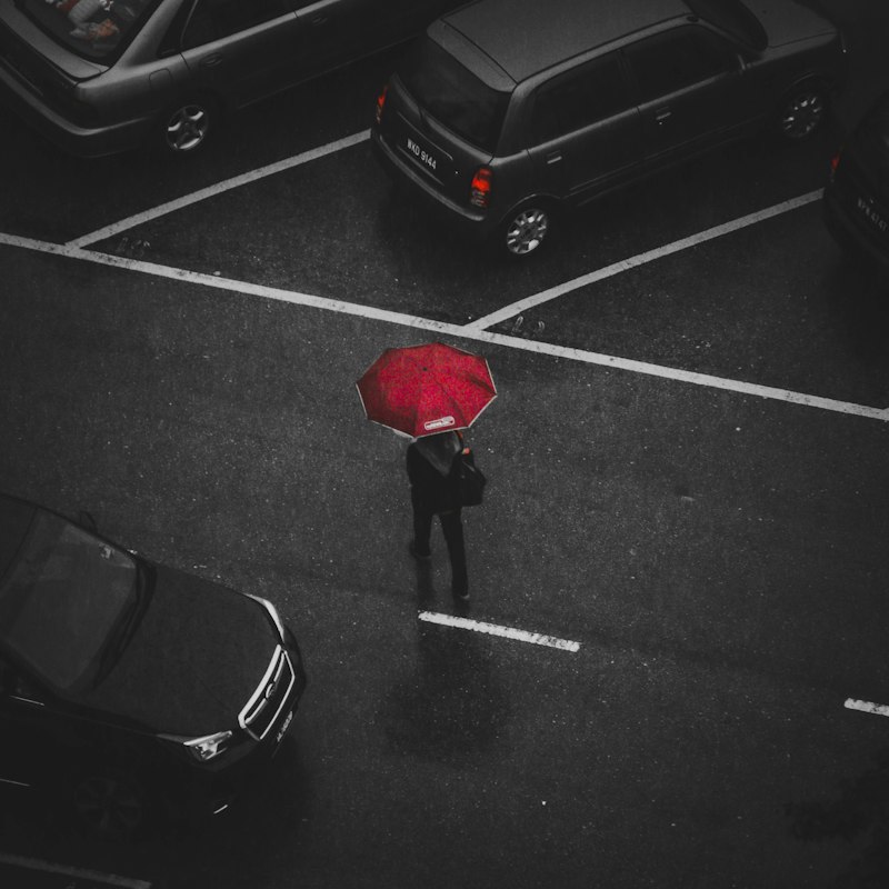 Parapluie rouge dans une rue grise