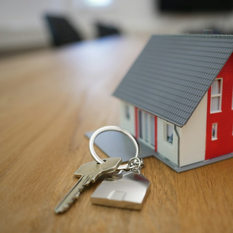 Clés posées devant une maquette de maison