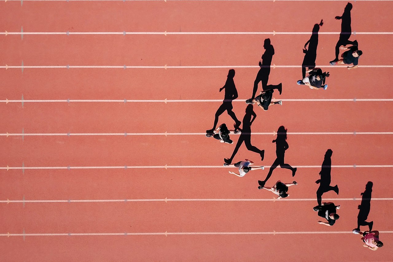 Coureurs vus du ciel sur une piste d'athlétisme rouge