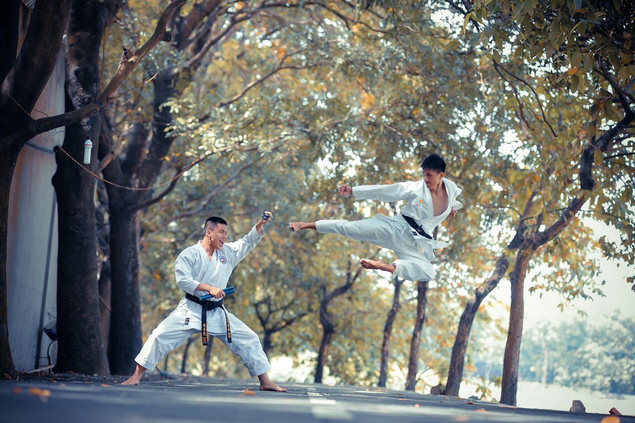 Deux pratiquants d'arts martiaux en kimono pendant une démonstration en extérieur