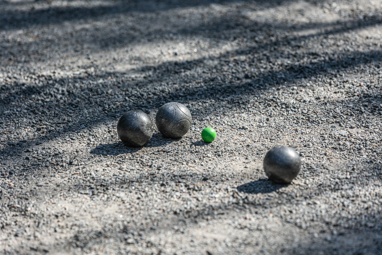 Boules de pétanque et cochonnet sur un terrain en gravier