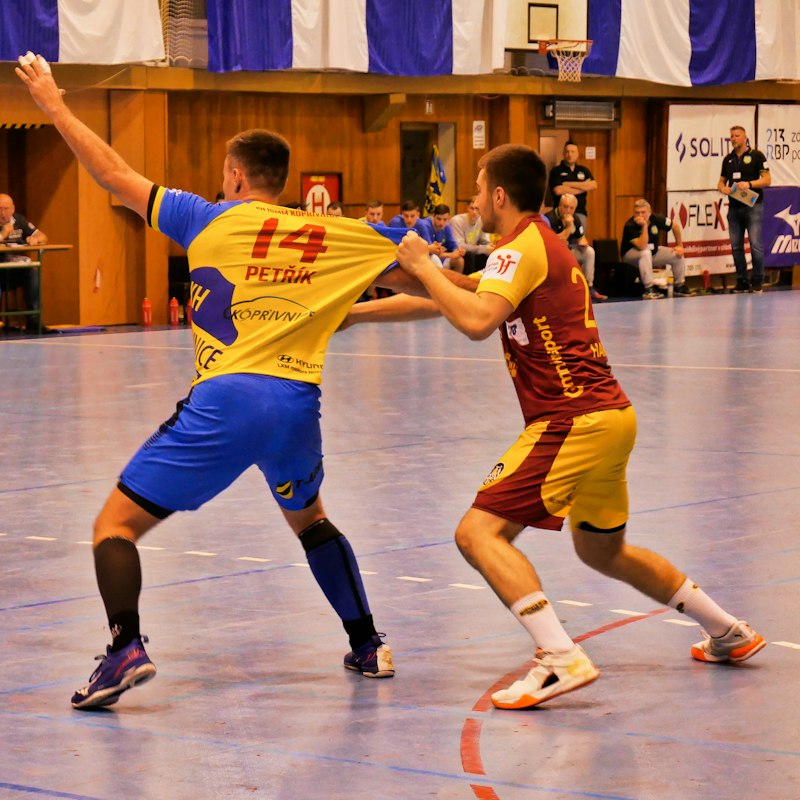 Joueurs de handball en maillots jaune et bleu lors d'un duel