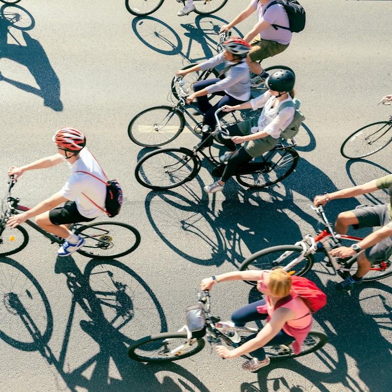 Groupe de cyclistes roulant ensemble sur une route, vu du dessus